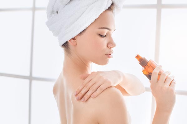 背中のスキンケアをする女性