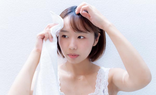 おでこの汗を拭く女性
