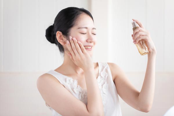 スプレー化粧水を使用する女性