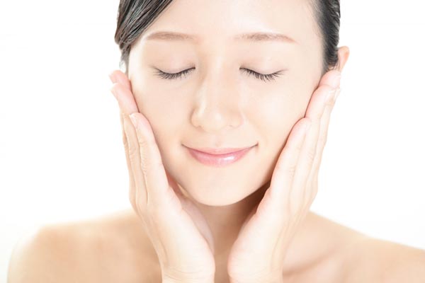 ハンドプレスで化粧品を浸透させる女性