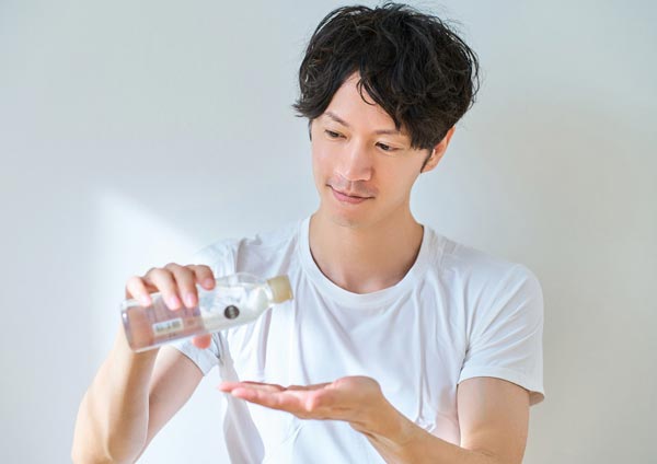 化粧水を手に取る男性