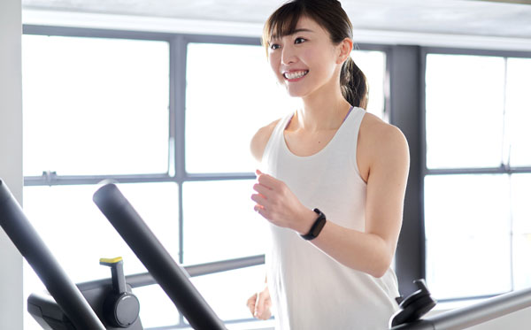 ランニングマシンで運動する女性