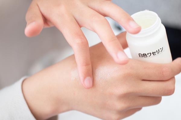 白色ワセリンを手に塗る人