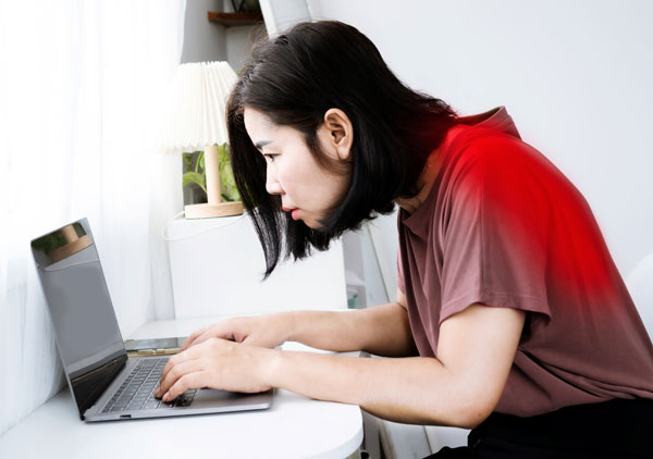 猫背でPC作業する女性