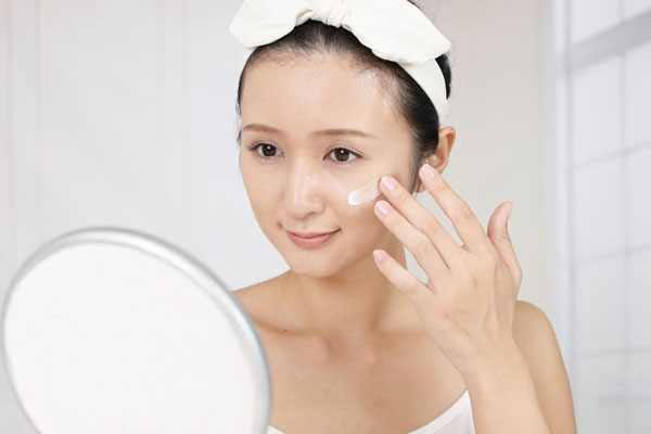 保湿クリームを肌につける女性