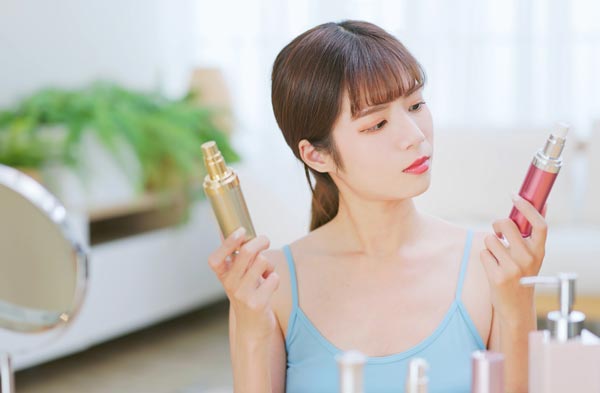 化粧品を両手に持つ女性