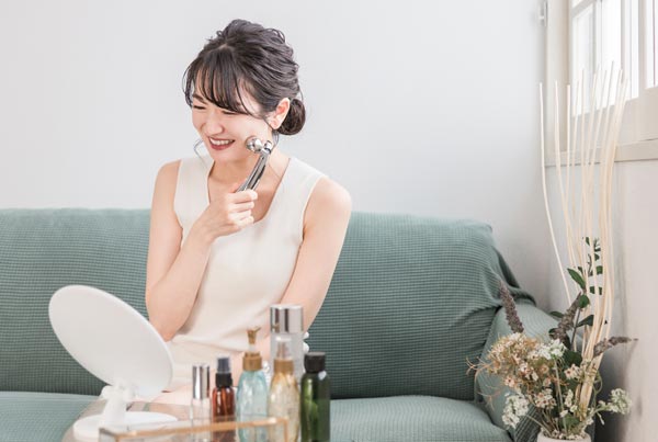 美顔器で顔をマッサージする女性