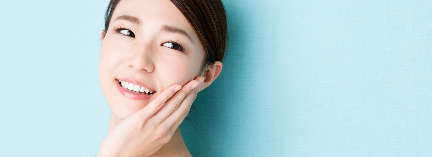 頬に手を当て笑顔の女性