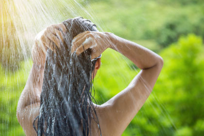 頭からシャワーを浴びる女性