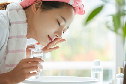 化粧水を顔につける女性