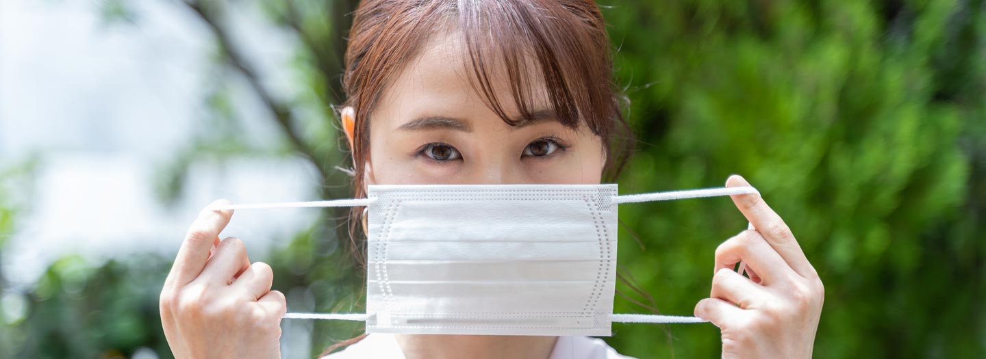 マスクで顔を隠す女性