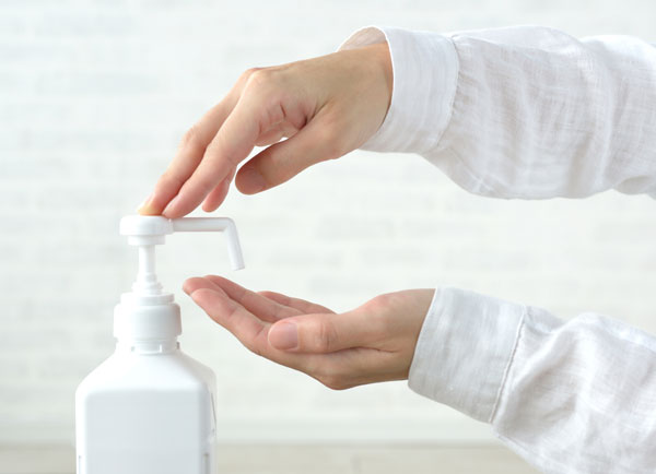 手にアルコール消毒液をかける