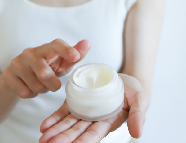 化粧品のクリームを手に取る