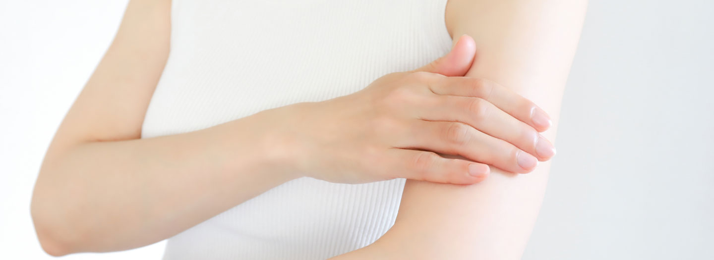 乾燥した自分の腕に触れる人