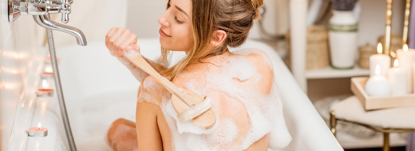 バスタブの中で背中を洗う女性