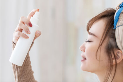化粧水スプレーを顔につける女性
