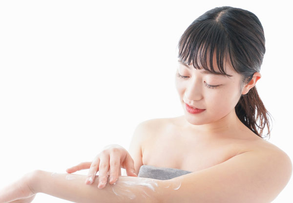 ボディクリームを腕に塗る女性