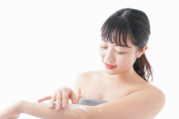 保湿クリームを腕に塗る女性