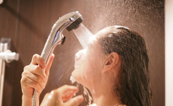シャワーを顔に浴びる女性