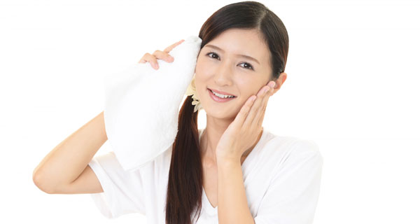 タオルで顔を拭く女性