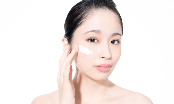 クリームを顔に塗る女性