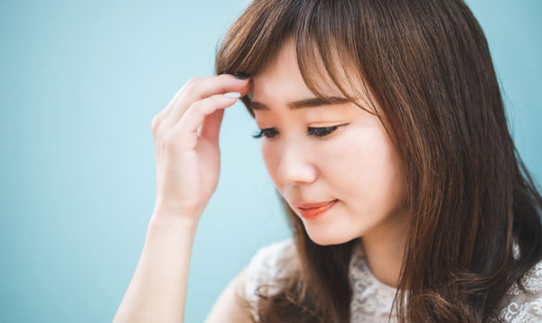 前髪を触る女性