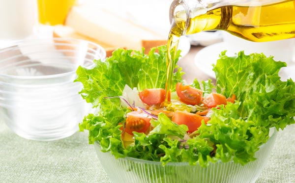 サラダにオリーブオイルをかける