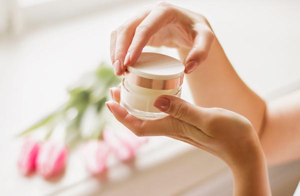 保湿クリームの容器を手に取る女性