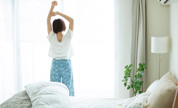 起きて朝日を浴びる女性